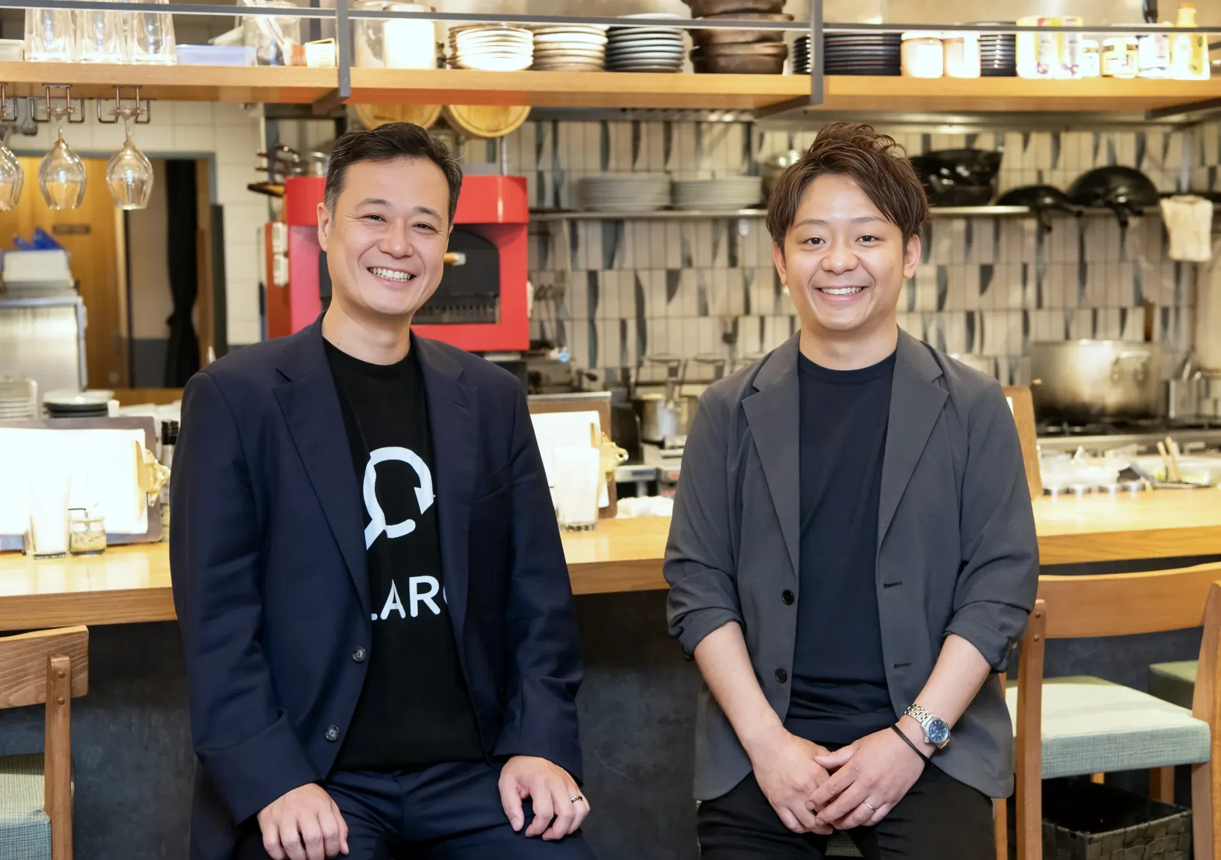 株式会社flaro代表 安部修平と株式会社イタリアンイノベーションクッチーナ代表取締役社長 青木秀一氏が店内で並ぶ写真